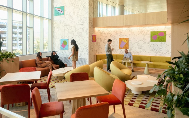 people in a lounge with tables, chairs and a couch