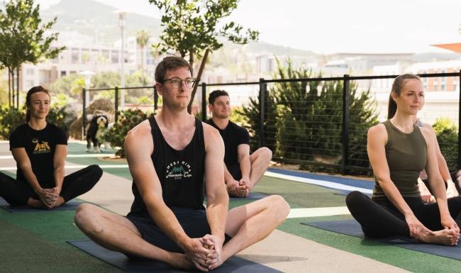 Settle into comfort at North City a group of people sitting on yoga mats outside